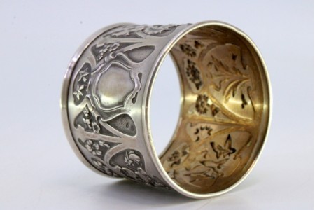 Argola de guardanapo em prata com relevos florais envolvendo cartela para monograma.